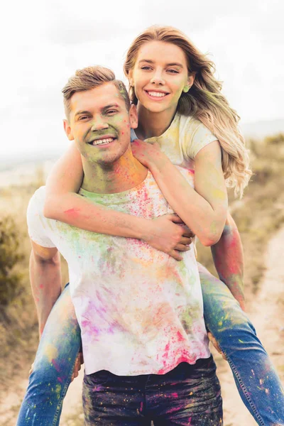 Handsome man piggybacking his smiling and attractive girlfriend outside — Stock Photo