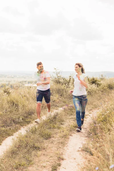 Atractiva mujer y hombre guapo sonriendo y corriendo fuera - foto de stock