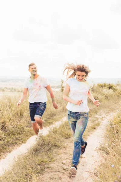Attraktive Frau und gutaussehender Mann lächelt und rennt nach draußen — Stockfoto