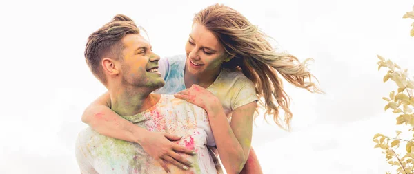 Panoramic shot of handsome man piggybacking his smiling and attractive girlfriend — Stock Photo