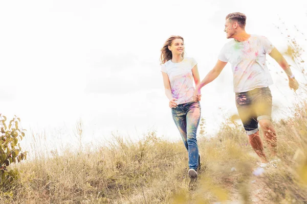 Attractive woman and handsome man smiling and holding hands — Stock Photo