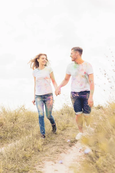 Attractive woman and handsome man smiling and holding hands — Stock Photo