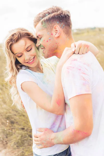 Séduisante femme et bel homme souriant et embrassant à l'extérieur — Photo de stock