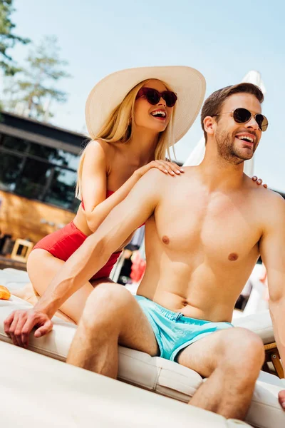 Lächeln sexy Mädchen mit Sonnenbrille sanft berührt Freund im Resort — Stockfoto