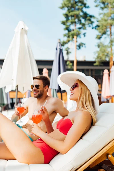 Sexy Paar liegt mit Cocktails auf Liegestühlen im Resort — Stockfoto