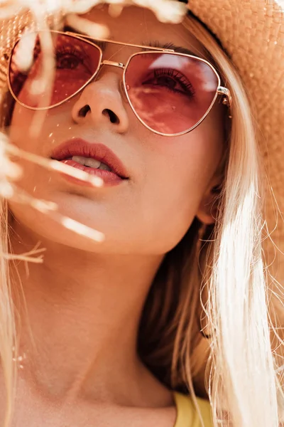 Chica atractiva pensativa en gafas de sol y sombrero de paja mirando hacia arriba - foto de stock