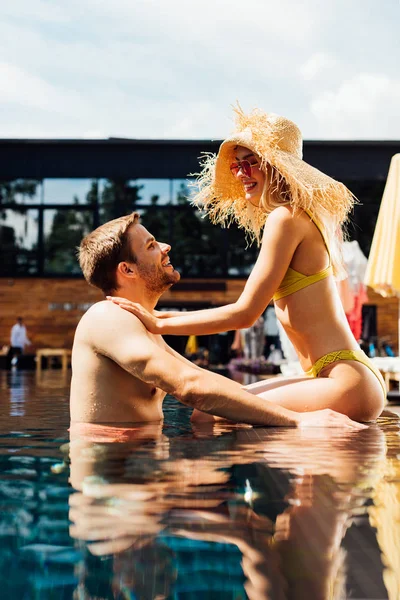 Sexy feliz pareja en piscina en día soleado - foto de stock