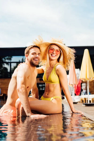 Sexy feliz casal abraçando na piscina no dia ensolarado — Fotografia de Stock