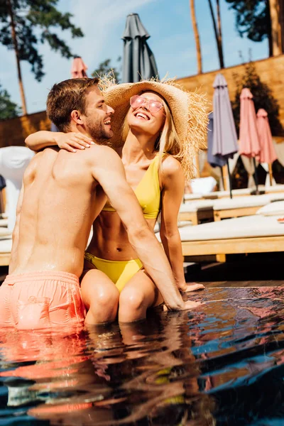 Sexy feliz casal abraçando na piscina no dia ensolarado — Fotografia de Stock