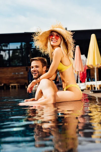 Sexy feliz pareja abrazando en piscina en día soleado - foto de stock