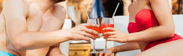 Panoramic shot of sexy couple clinking glasses of cocktails — Stock Photo