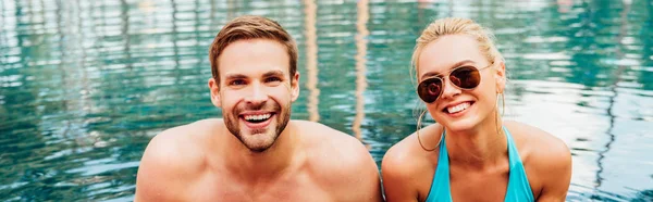 Tiro panorámico de la sexy pareja riendo en la piscina - foto de stock