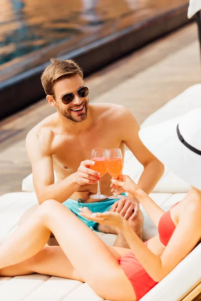Sexy couple clinking glasses of cocktails at resort in sunny day — Stock Photo