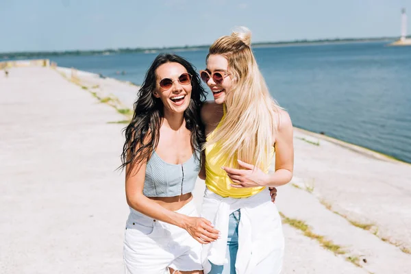 Meninas rindo felizes andando perto do rio no verão — Fotografia de Stock