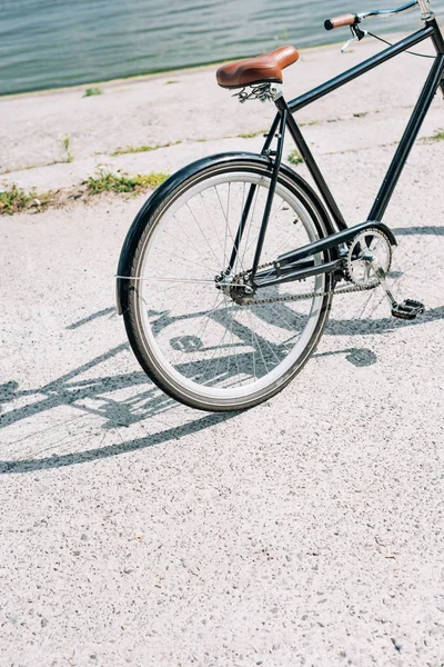 Bicicleta no asfalto perto do rio azul no verão — Fotografia de Stock