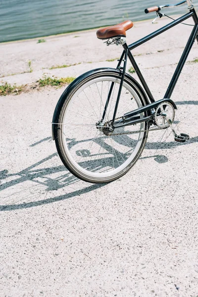 Fahrrad auf Asphalt nahe blauem Fluss im Sommer — Stockfoto