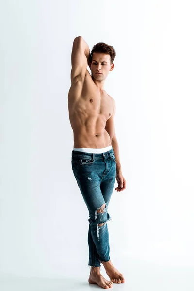 Uomo sexy a piedi nudi in piedi in jeans su bianco — Foto stock
