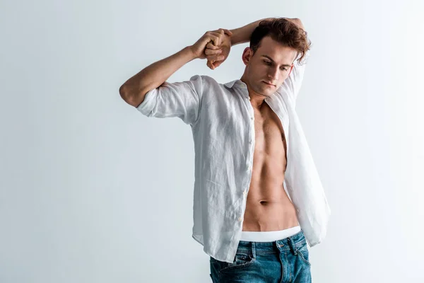 Bello giovane uomo in camicia e jeans di jeans in piedi su bianco — Foto stock