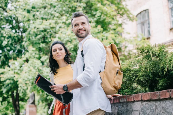 Glücklicher bärtiger Mann mit Landkarte neben attraktiver Frau — Stockfoto