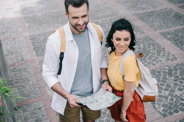 Overhead view of happy woman standing near man with map — Stock Photo