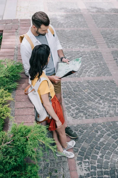 Enfoque selectivo de la mujer mirando el mapa cerca del hombre barbudo - foto de stock