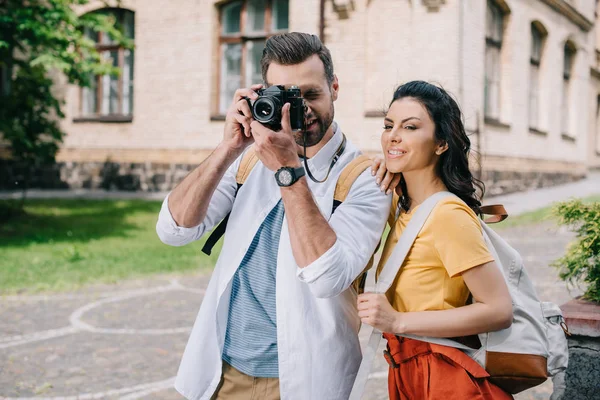 Homme barbu couvrant visage tout en prenant une photo près de la femme — Photo de stock