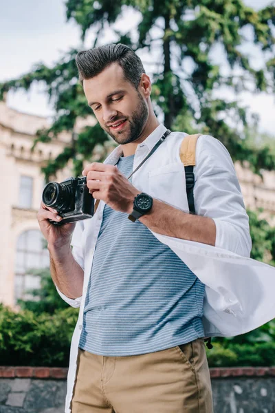 Glücklicher bärtiger Mann mit Digitalkamera in der Nähe eines Gebäudes — Stockfoto