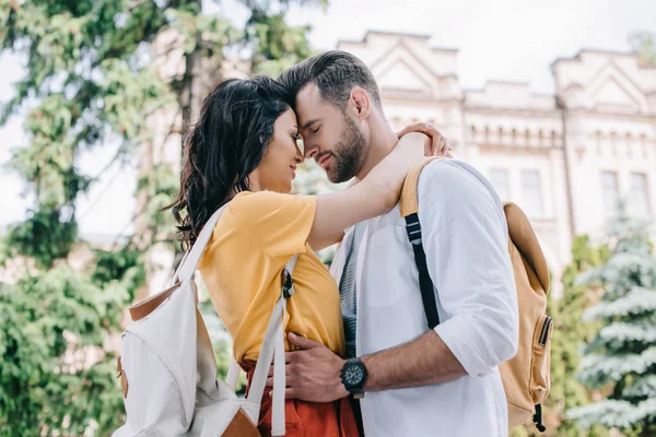 Mujer feliz abrazando novio barbudo cerca del edificio - foto de stock