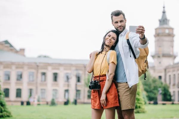 Glücklicher bärtiger Mann und attraktive Frau machen Selfie in der Nähe des Gebäudes — Stockfoto