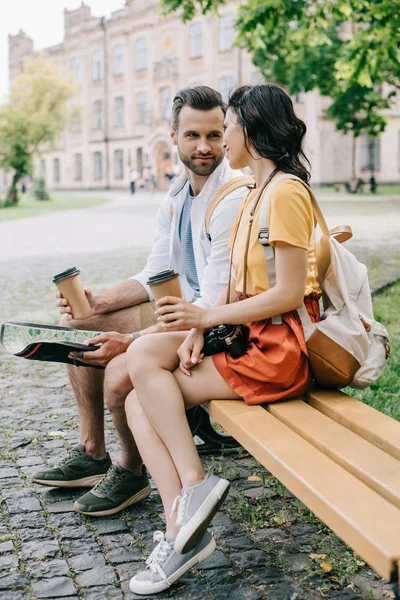 Handsome man holding map and paper cup near girl — Stock Photo