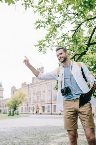 Uomo felice che tiene con il dito mentre tiene la mappa — Foto stock