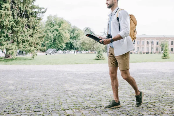 Ausgeschnittene Ansicht eines bärtigen Mannes, der eine Karte hält und in der Stadt spazieren geht — Stockfoto