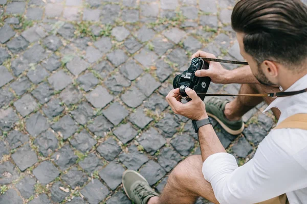 Overhead view of man holding digital camera in hands — Stock Photo