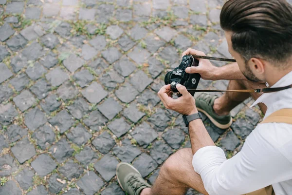 Vue aérienne de l'homme tenant un appareil photo numérique dans les mains — Photo de stock