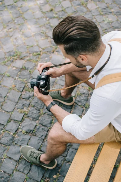 Vue aérienne de l'homme barbu tenant l'appareil photo numérique dans les mains — Photo de stock