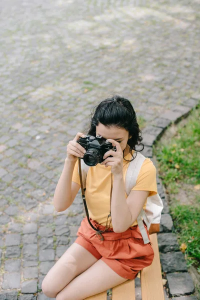 Overhead view of girl taking photo on digital camera outside — Stock Photo