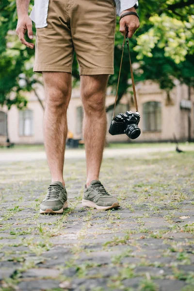 Ausgeschnittene Ansicht eines Mannes, der mit Digitalkamera draußen steht — Stockfoto