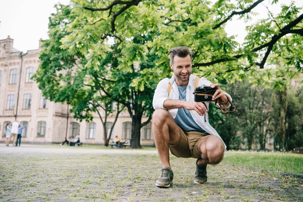 Happy bearded man taking selfie on digital camera near building — Stock Photo