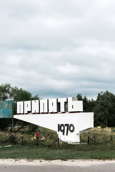 PRIPYAT, UKRAINE - 15 AOÛT 2019 : monument avec lettrage pripyat près des arbres à l'extérieur — Photo de stock