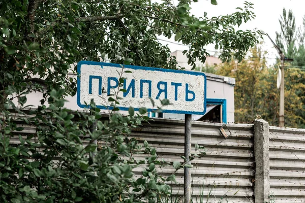 Pripyat, Ukraine - 15. August 2019: Schild mit Pripyat-Schriftzug in der Nähe von Bäumen und Zaun — Stockfoto