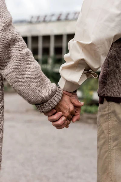 Обрезанный вид мужа и жены на пенсии, держащихся за руки — стоковое фото