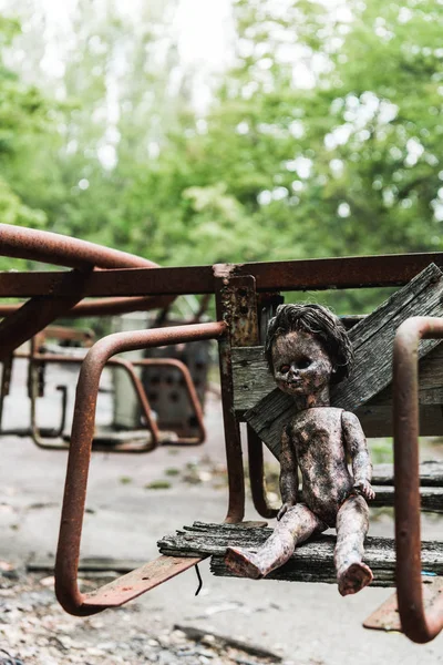 Selective focus of dirty baby doll on abandoned carousel in chernobyl — Stock Photo