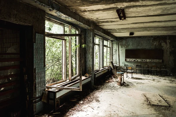 Aula abandonada con sillas sucias en la escuela - foto de stock