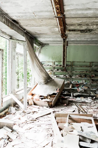 Gruselige und verlassene Bibliothek mit Büchern auf dem Fußboden in der Schule — Stockfoto