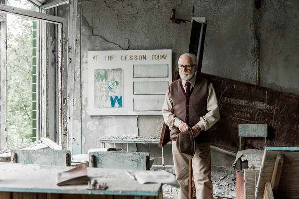 Selektiver Fokus eines Rentners mit Hut, während er in der Nähe von Bord mit Buchstaben steht — Stockfoto