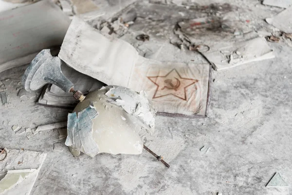 PRIPYAT, UCRAINA - 15 AGOSTO 2019: globo rotto vicino al cartello sindacale sovietico sul pavimento sporco — Foto stock