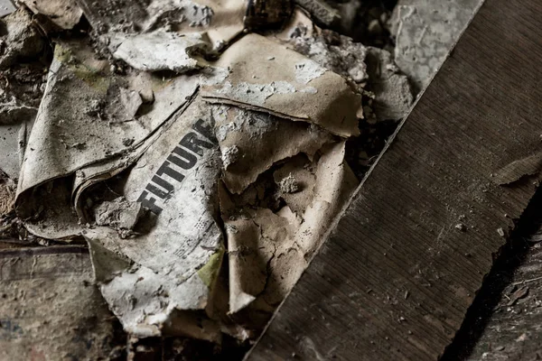 Periódico quemado con futuras letras en el suelo sucio - foto de stock
