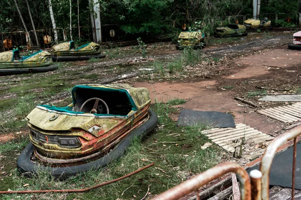 PRIPYAT, UKRAINE - AUGUST 15, 2019: selective focus of abandoned and damaged bumper cars in amusement park — Stock Photo