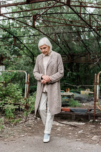 PRIPYAT, UCRANIA - 15 de agosto de 2019: mujer mayor molesta caminando en el parque de atracciones - foto de stock