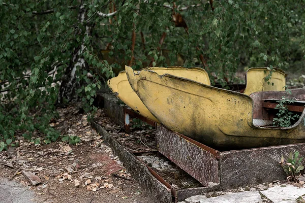 PRIPYAT, UCRÂNIA - AGOSTO 15, 2019: árvores perto de construções metálicas abandonadas no parque de diversões — Fotografia de Stock